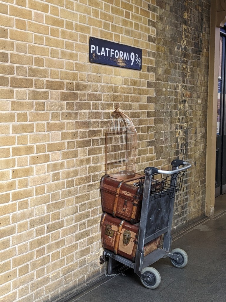 photo-opportunity-with-harry-potter's-luggage-trolley-going-through-the-wall-of-platform-9-3/4-at-kings-cross-station-london