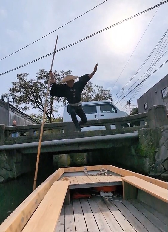 The-Yanagawa-Boatman-leaps-with-his-pole-onto-the-bridge-as-we-pass-under-then-lands-samurai-style-back-onto-the-boat-as-it-emerges-out-the-other-side