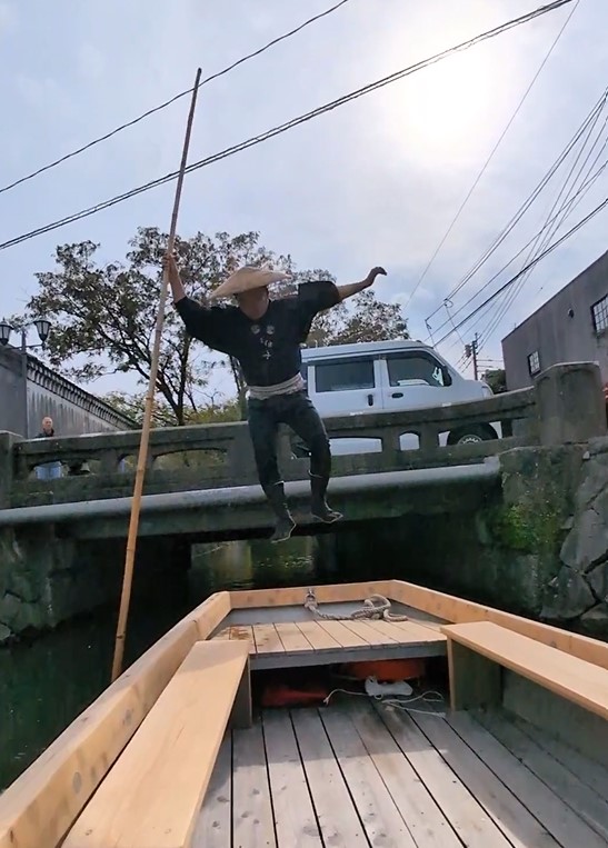 The-Yanagawa-Boatman-leaps-with-his-pole-onto-the-bridge-as-we-pass-under-then-lands-samurai-style-back-onto-the-boat-as-it-emerges-out-the-other-side